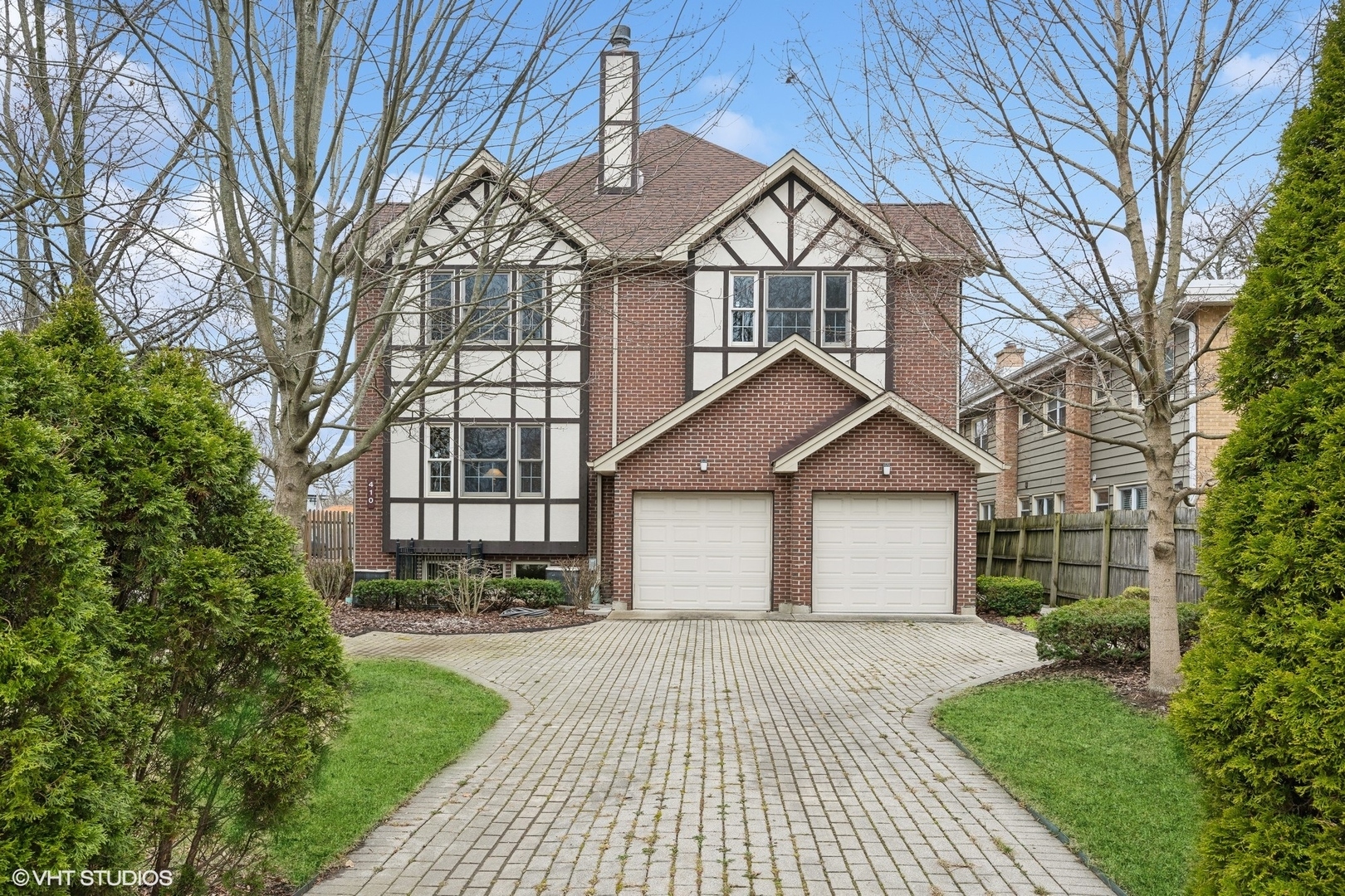 a front view of a house with a yard and trees