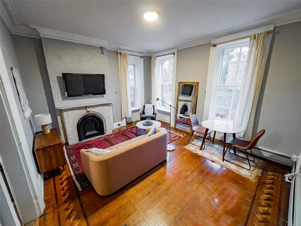 Living room with hardwood / wood-style flooring and ornamental molding