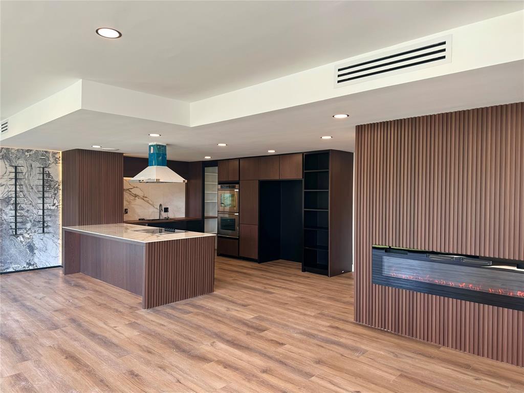 a kitchen with stainless steel appliances kitchen island wooden cabinets and fireplace