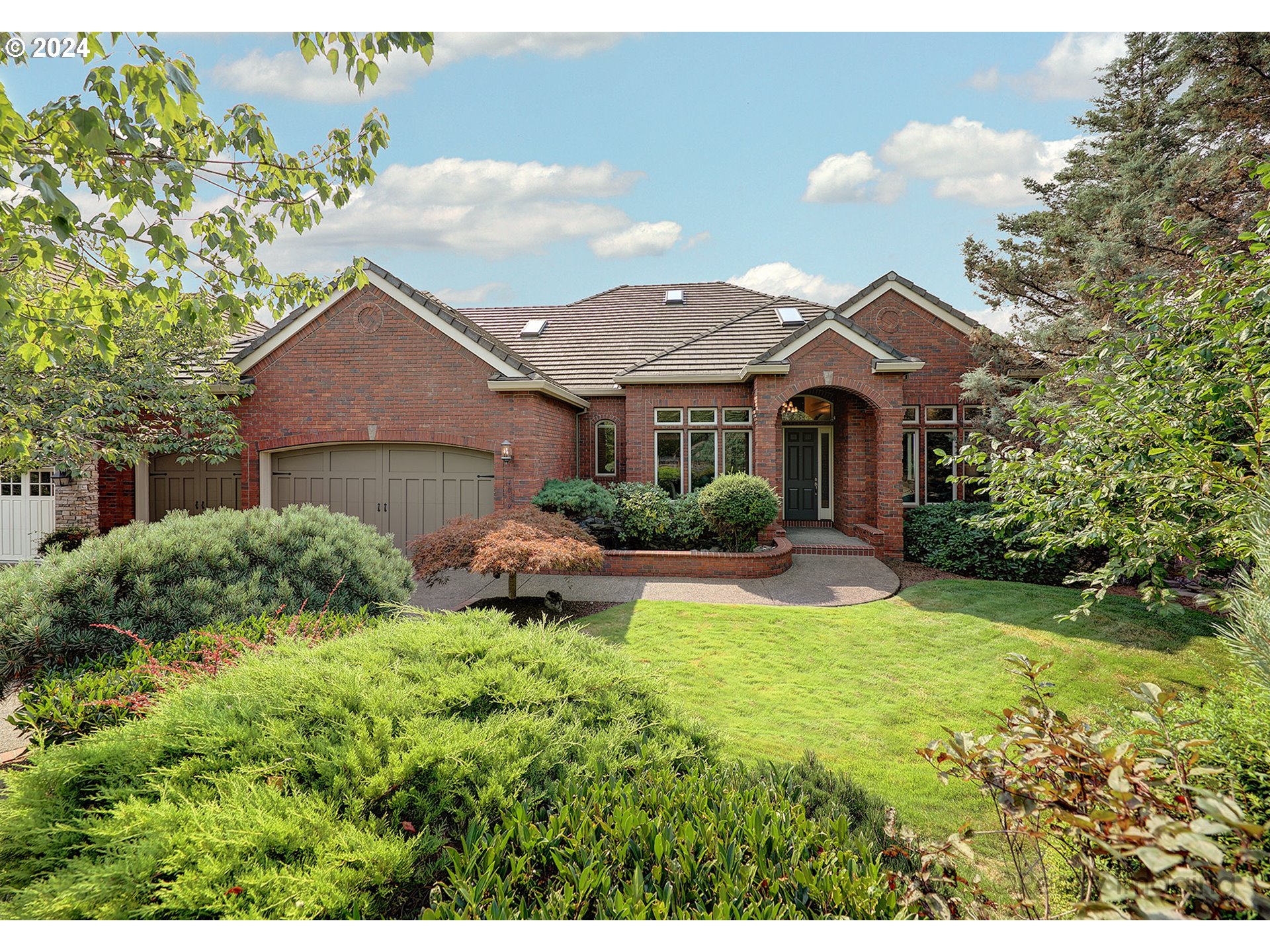 a front view of a house with yard and green space