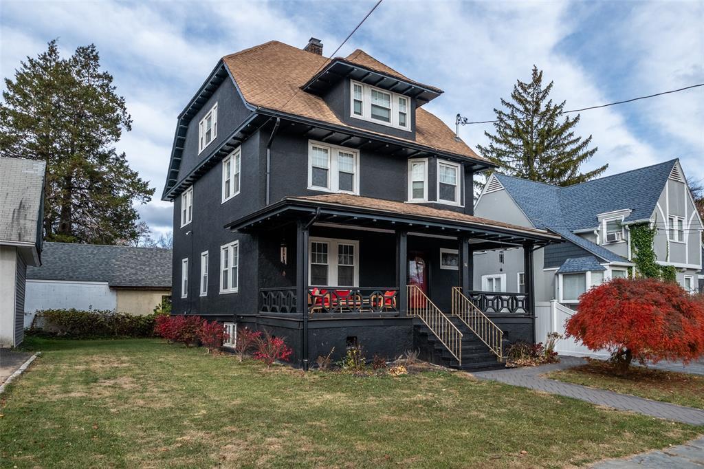 View of front facade with a front yard and a porch