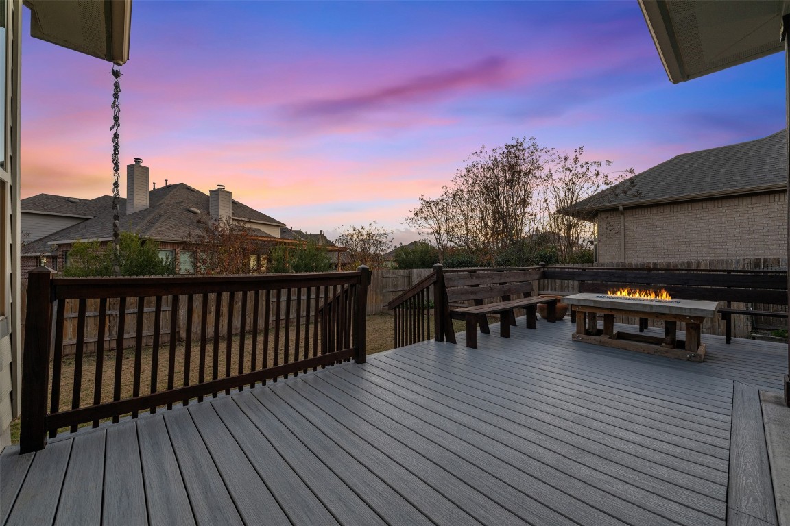 a view of a roof deck with table and chairs a barbeque with wooden floor and a potted plant