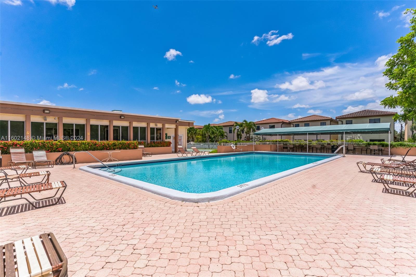 a view of a swimming pool with a patio and a yard