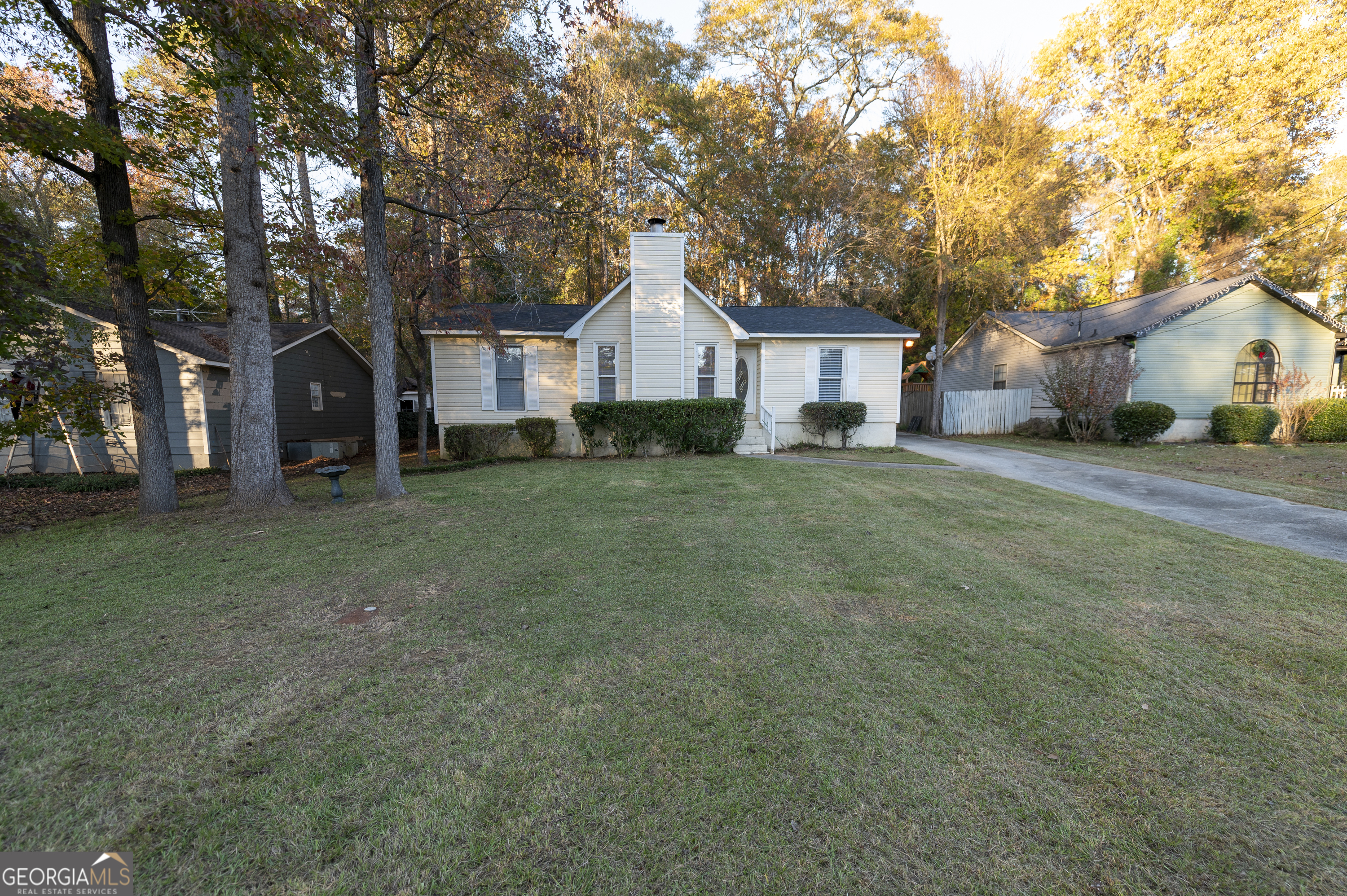 a front view of a house with a yard and trees