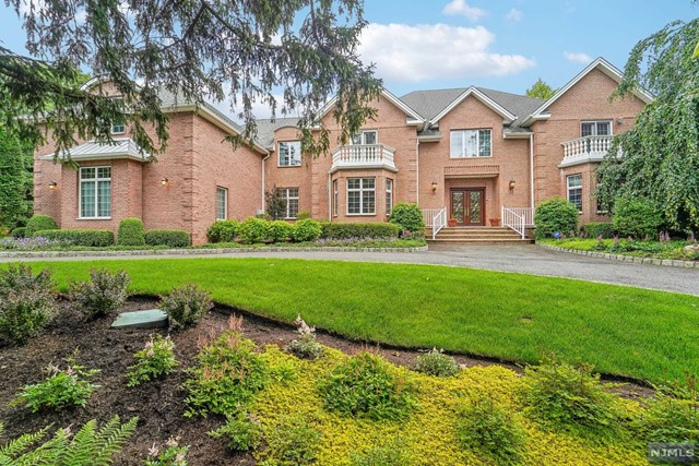 a front view of a house with a yard and green space