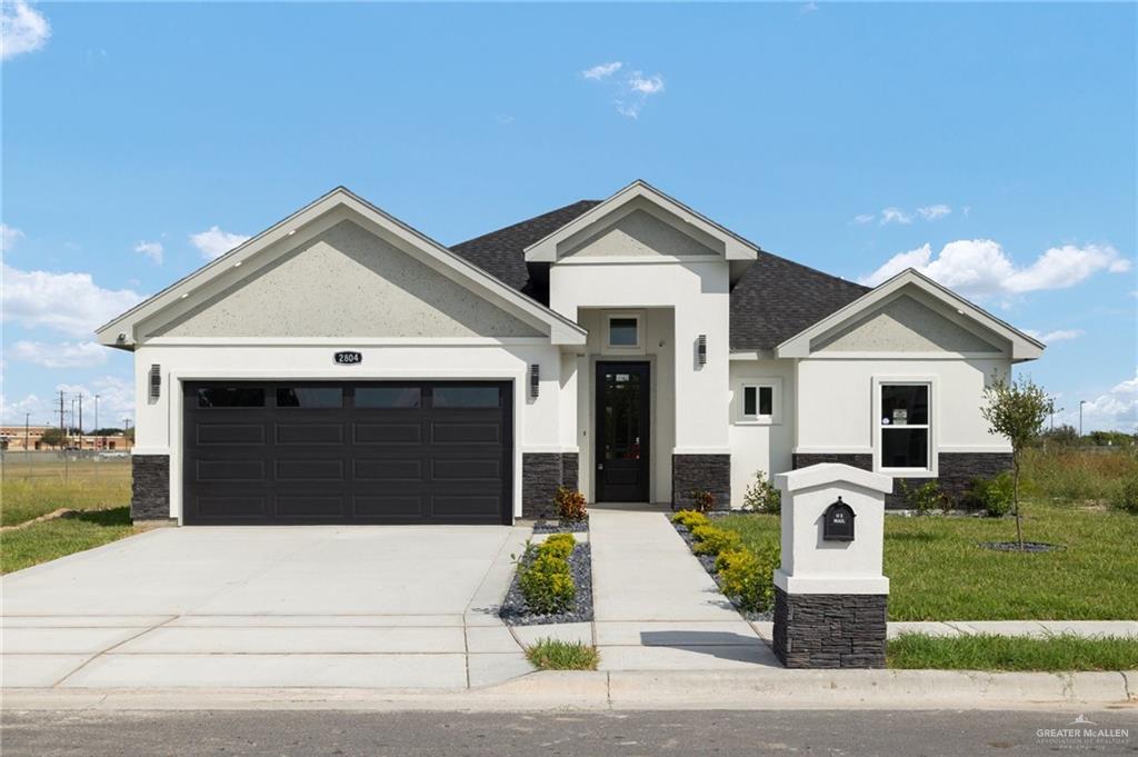 a front view of a house with a yard and garage