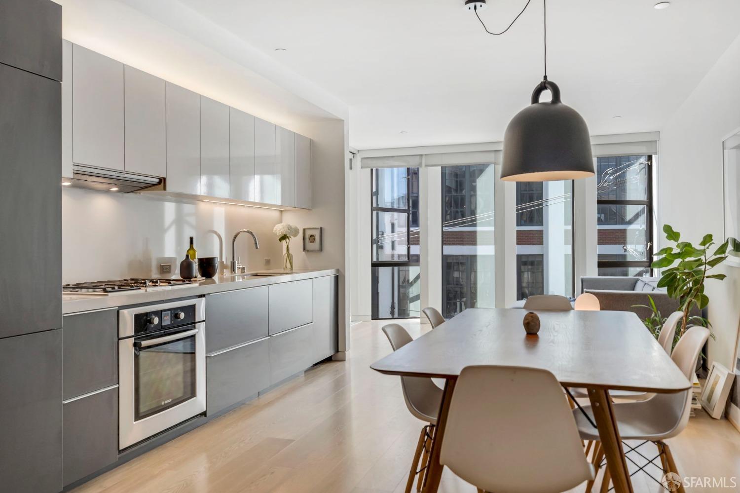 a kitchen with stainless steel appliances a dining table chairs and stove