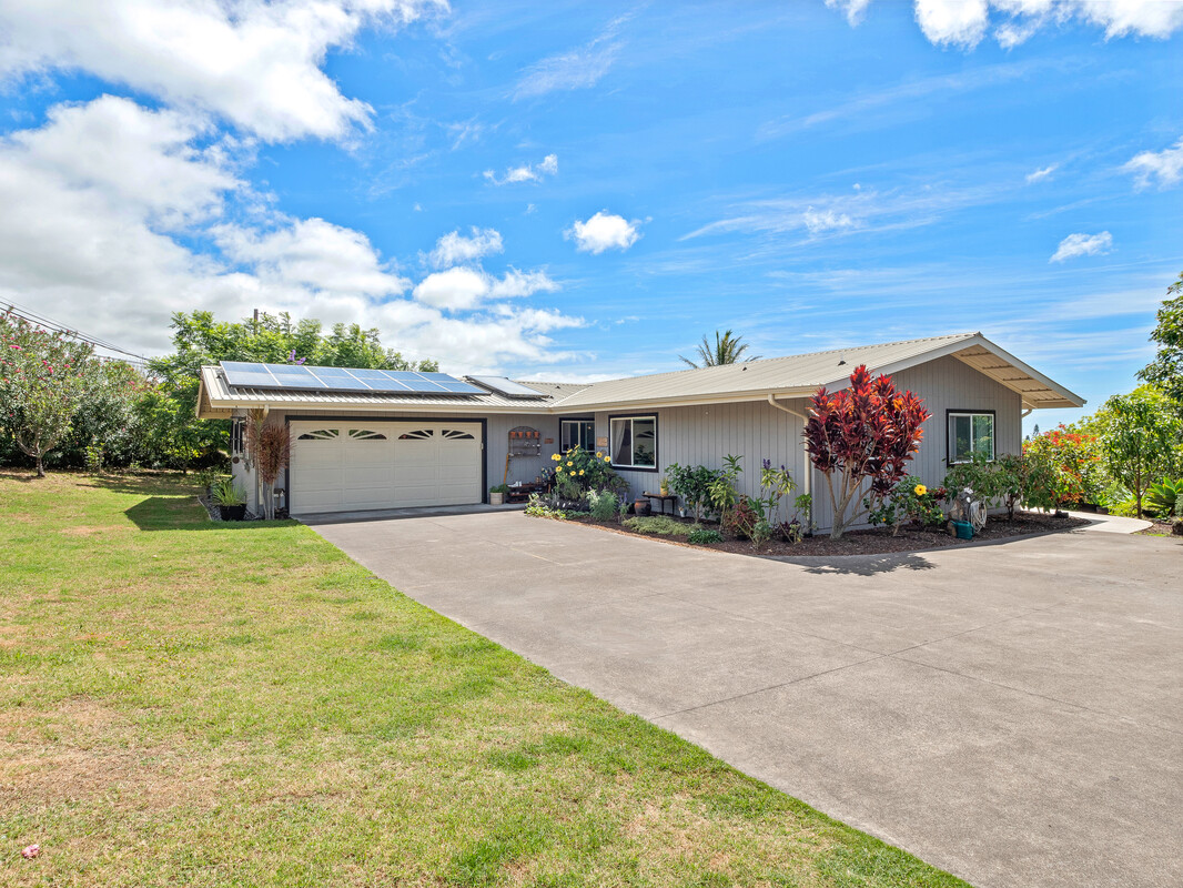 a front view of house with yard and trees in the background