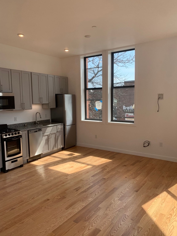 a view of kitchen with granite countertop window and refrigerator