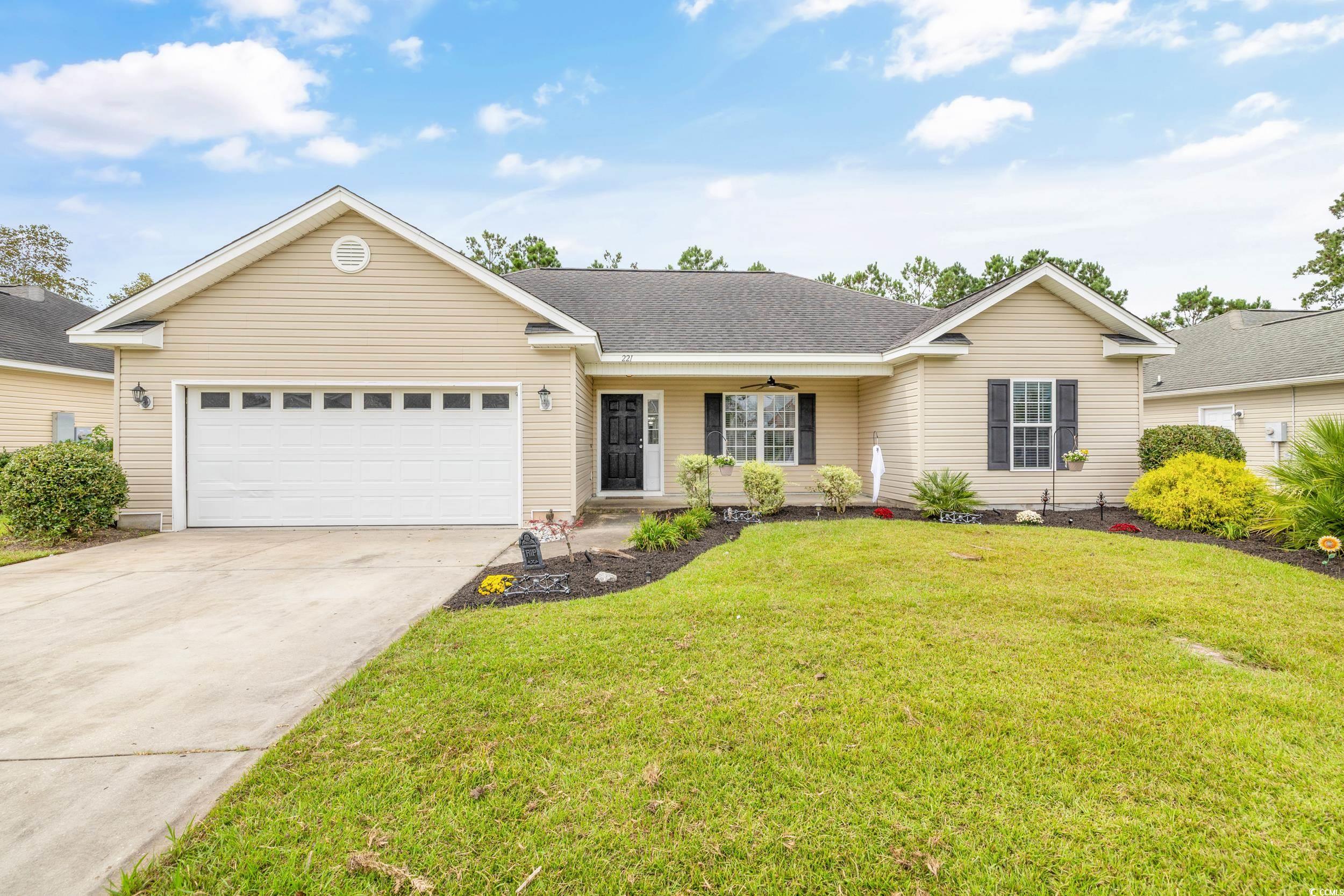 Ranch-style house featuring a front yard and a gar