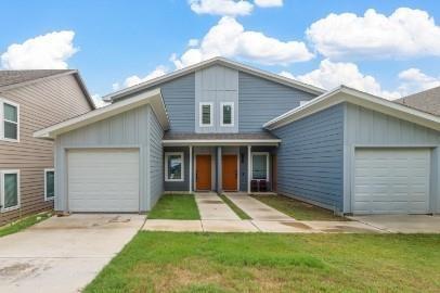 a view of a house with a yard and garage