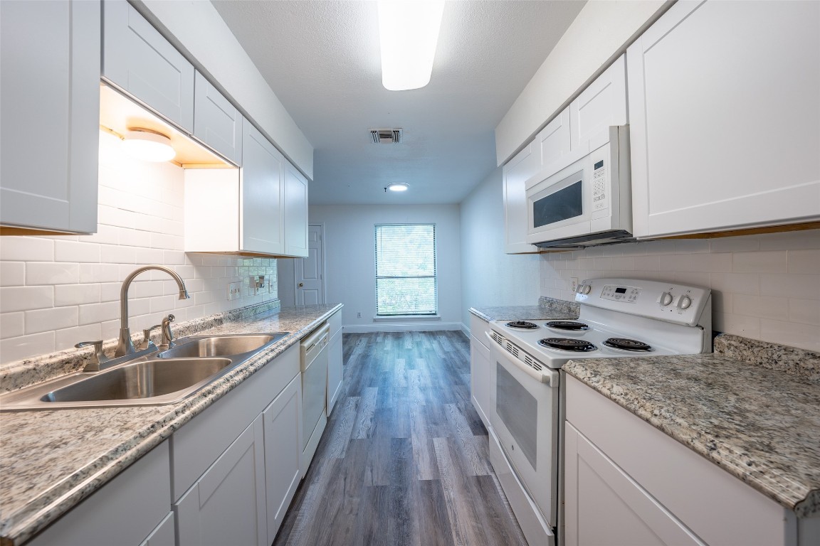 a kitchen with stainless steel appliances granite countertop a sink stove and cabinets