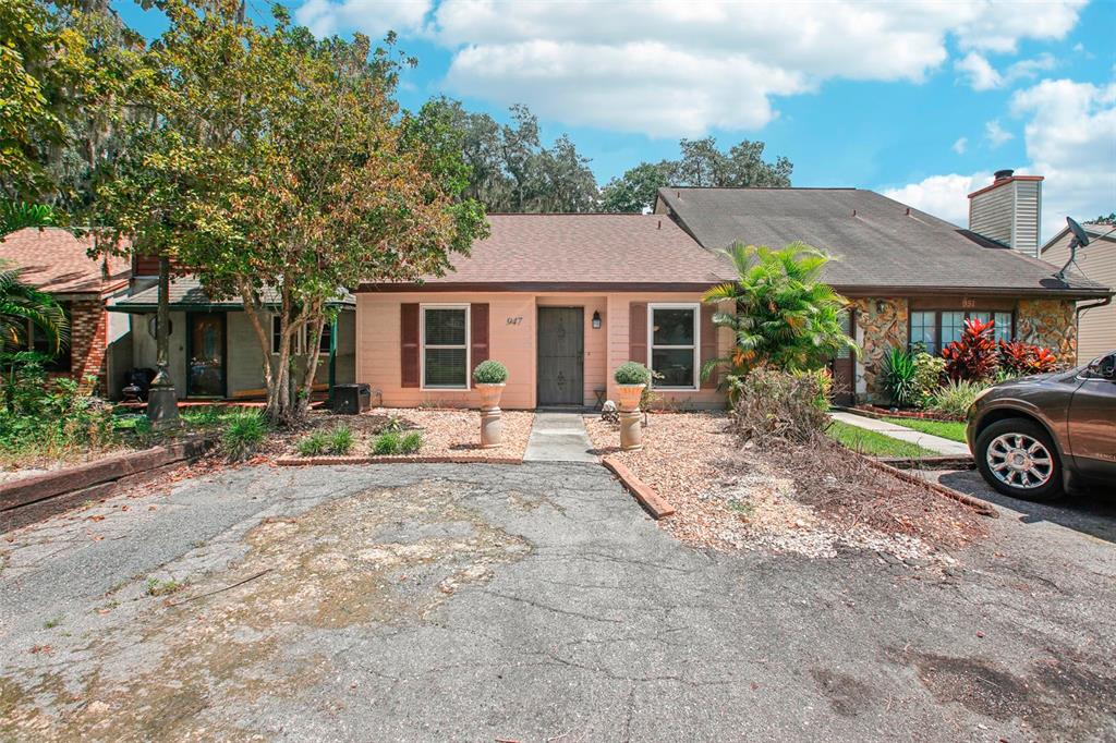 a view of a house with a yard and parking space