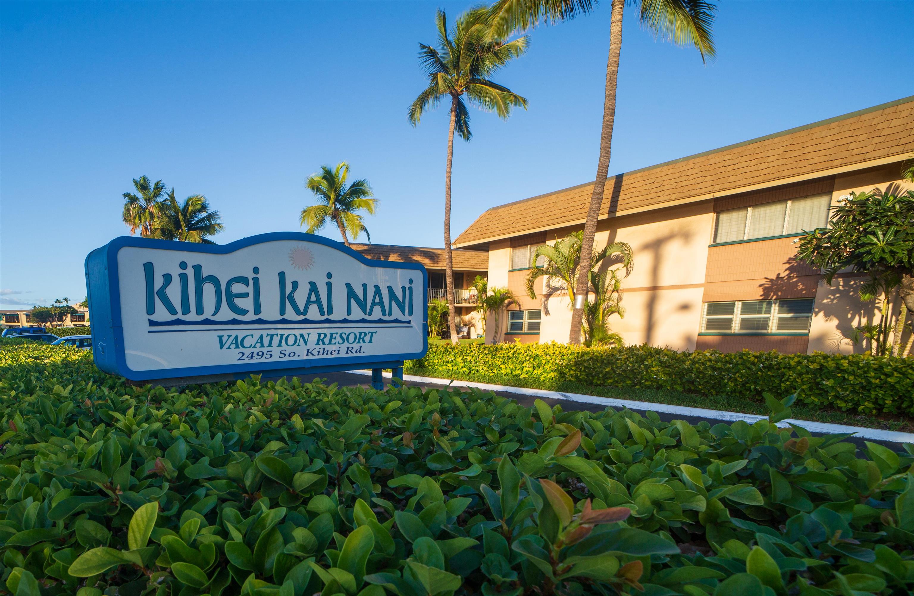 a view of a sign board with yard in the background