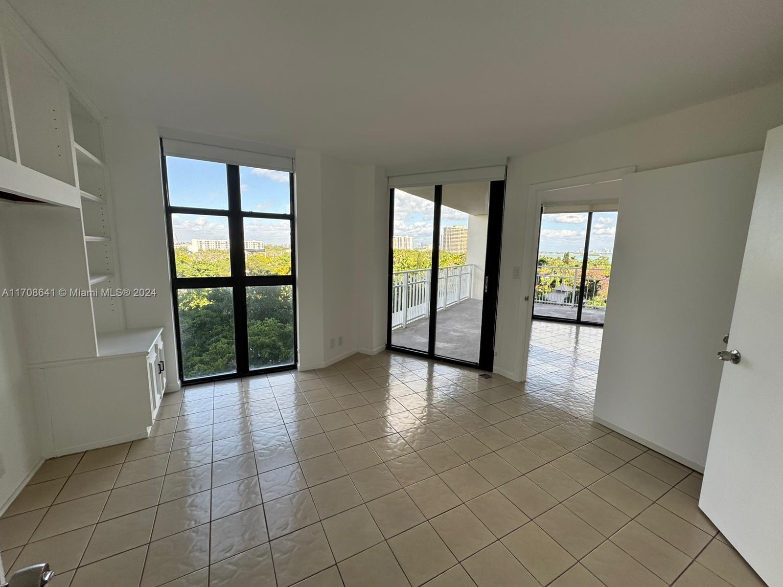 an empty room with windows and view of an empty room