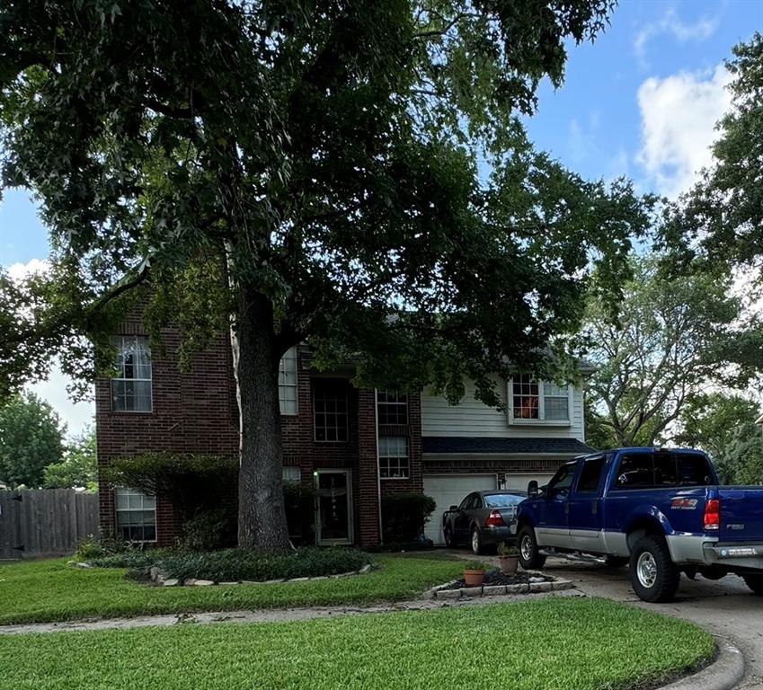 a view of a car parked in front of a house with a large tree