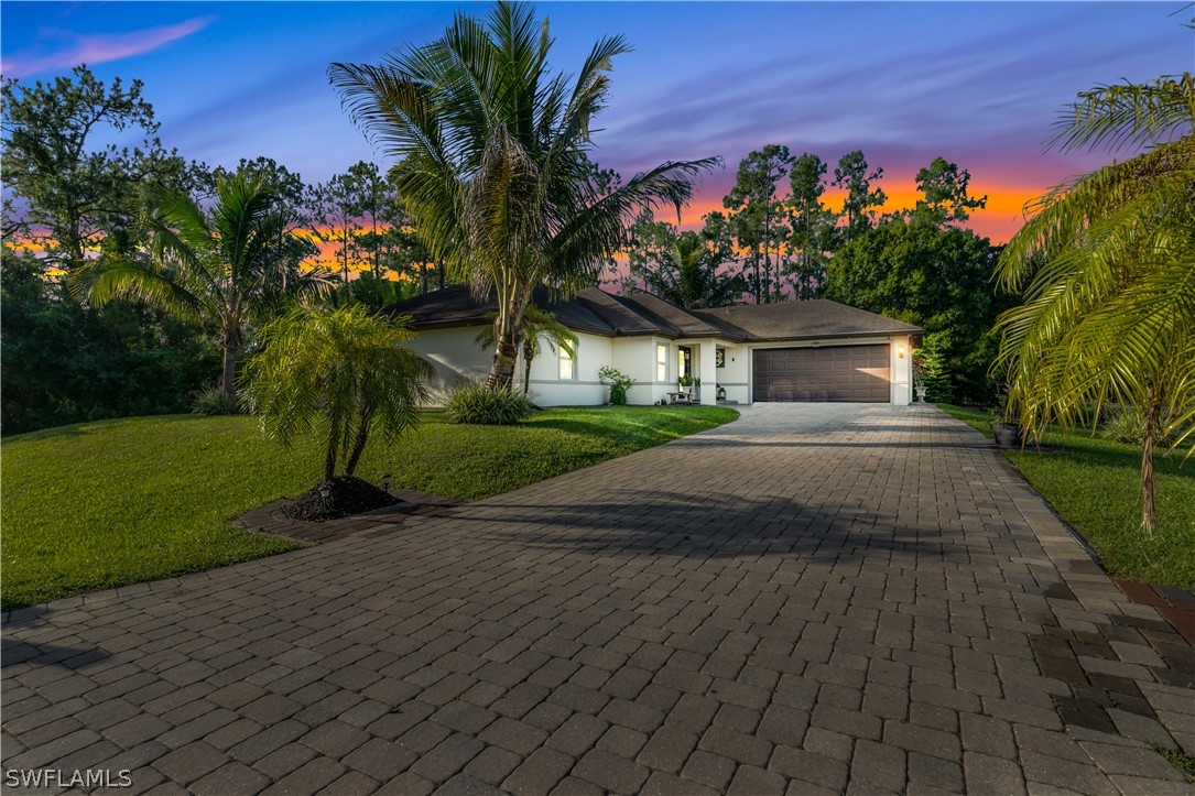 a front view of a house with a yard and a garage