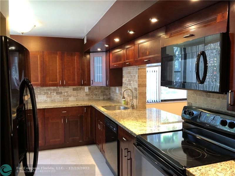 a kitchen with stainless steel appliances granite countertop a sink stove and cabinets