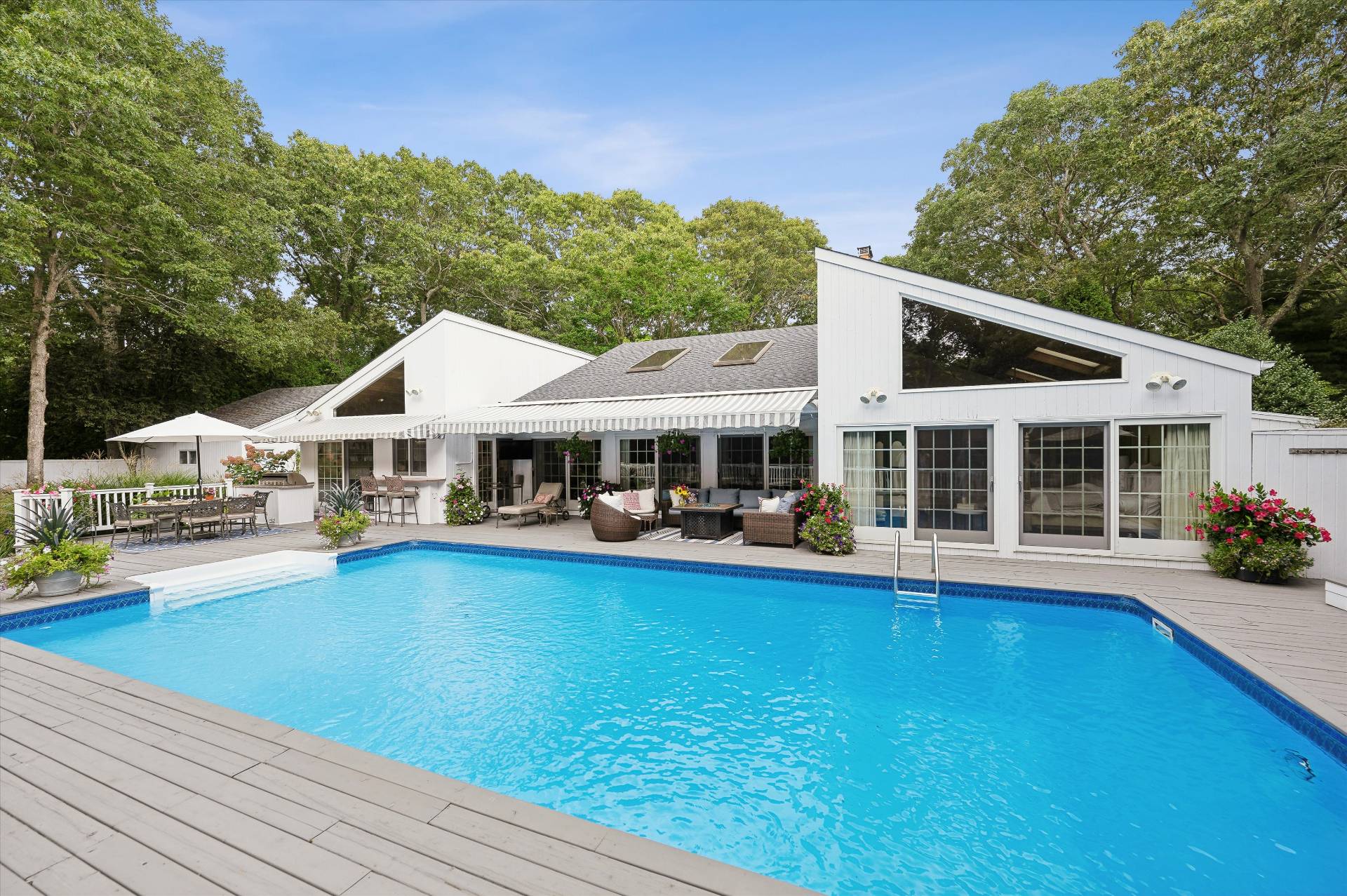 a front view of a house with swimming pool and porch with furniture