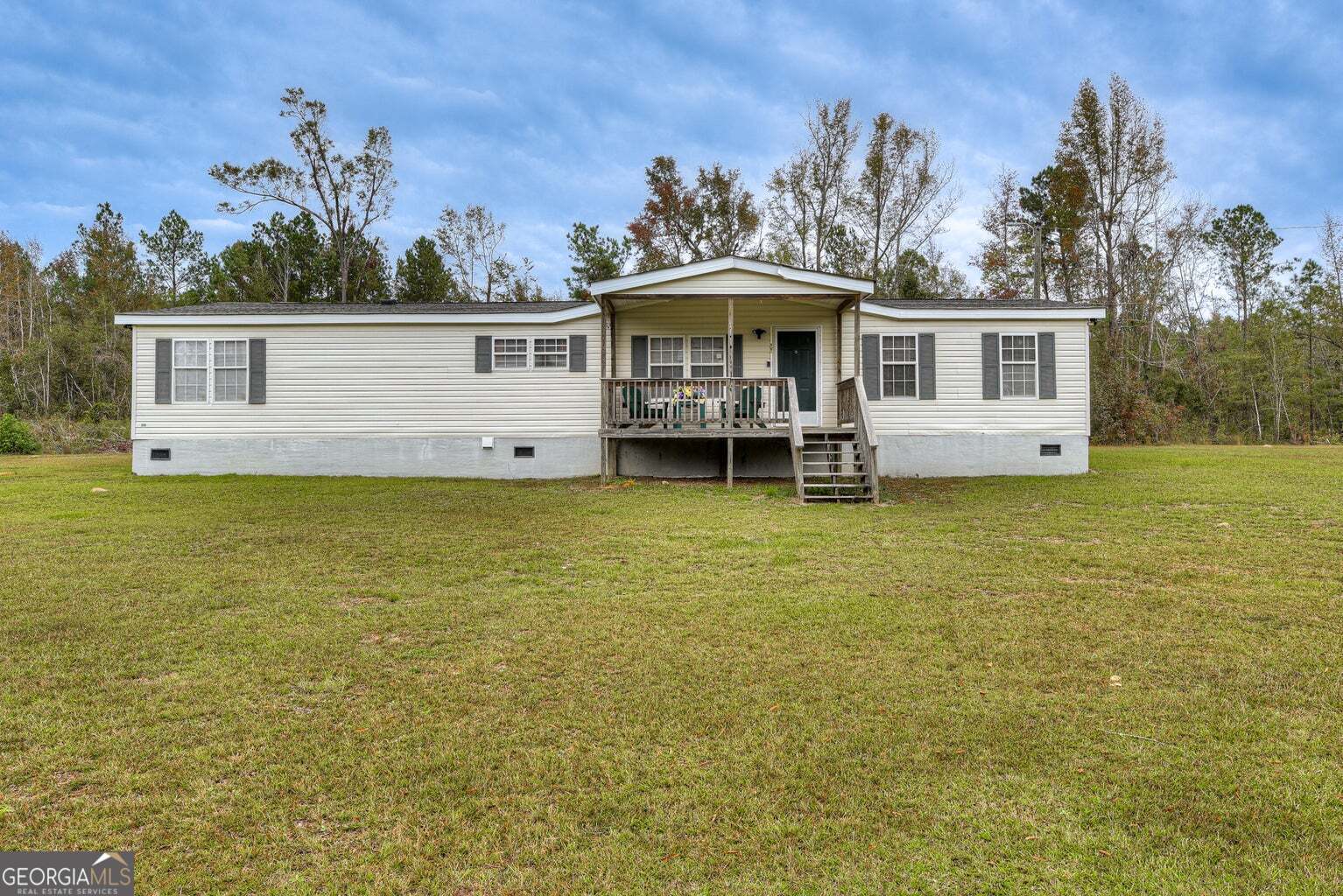 a front view of a house with a garden and yard