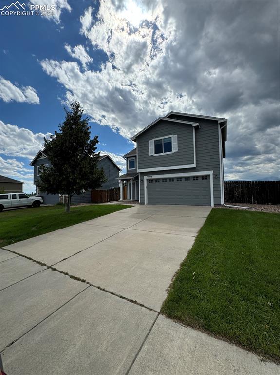 View of property with a garage and a front yard