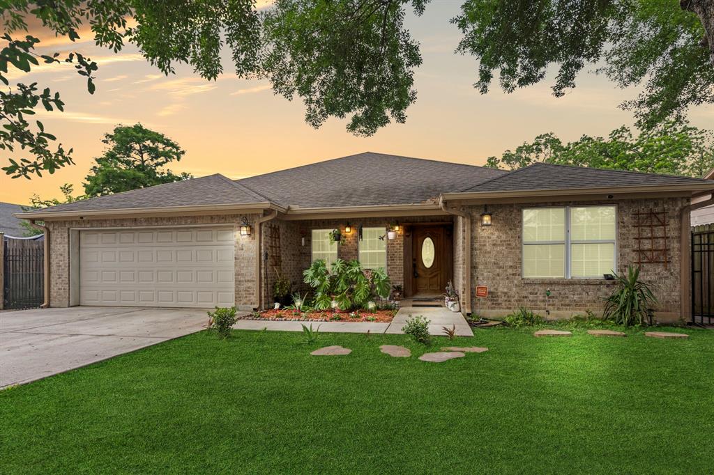 a front view of a house with a garden and yard