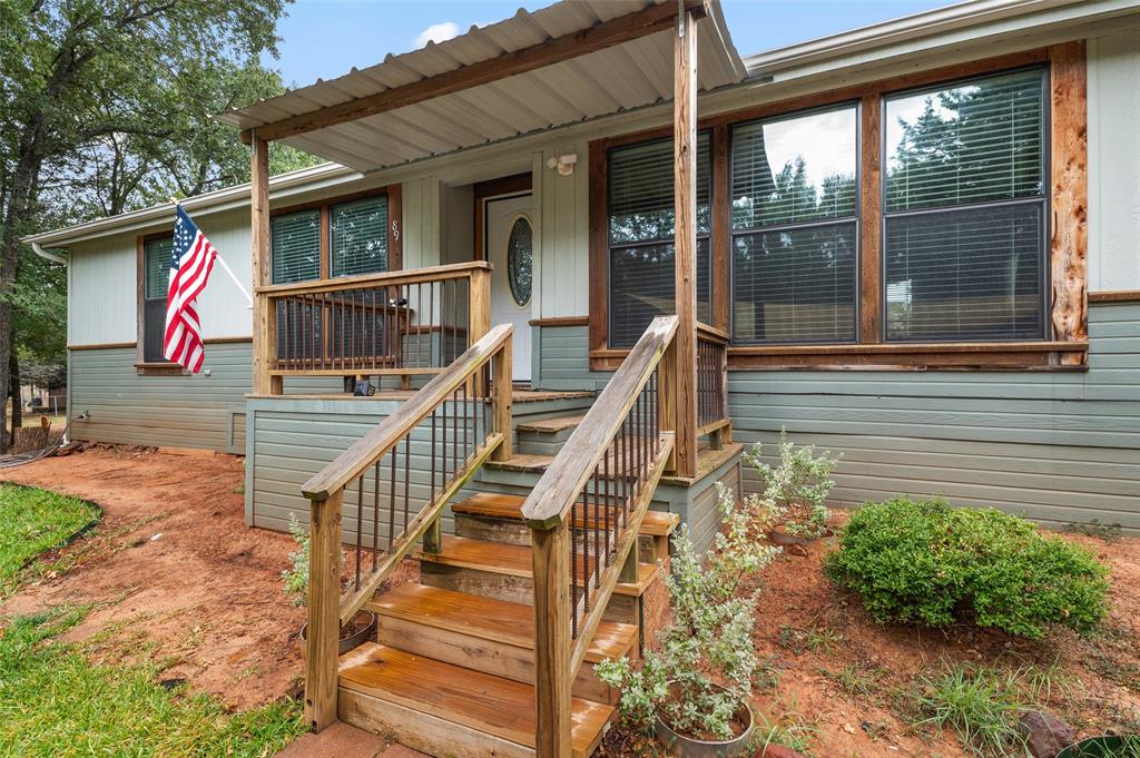 a view of house with wooden deck and furniture