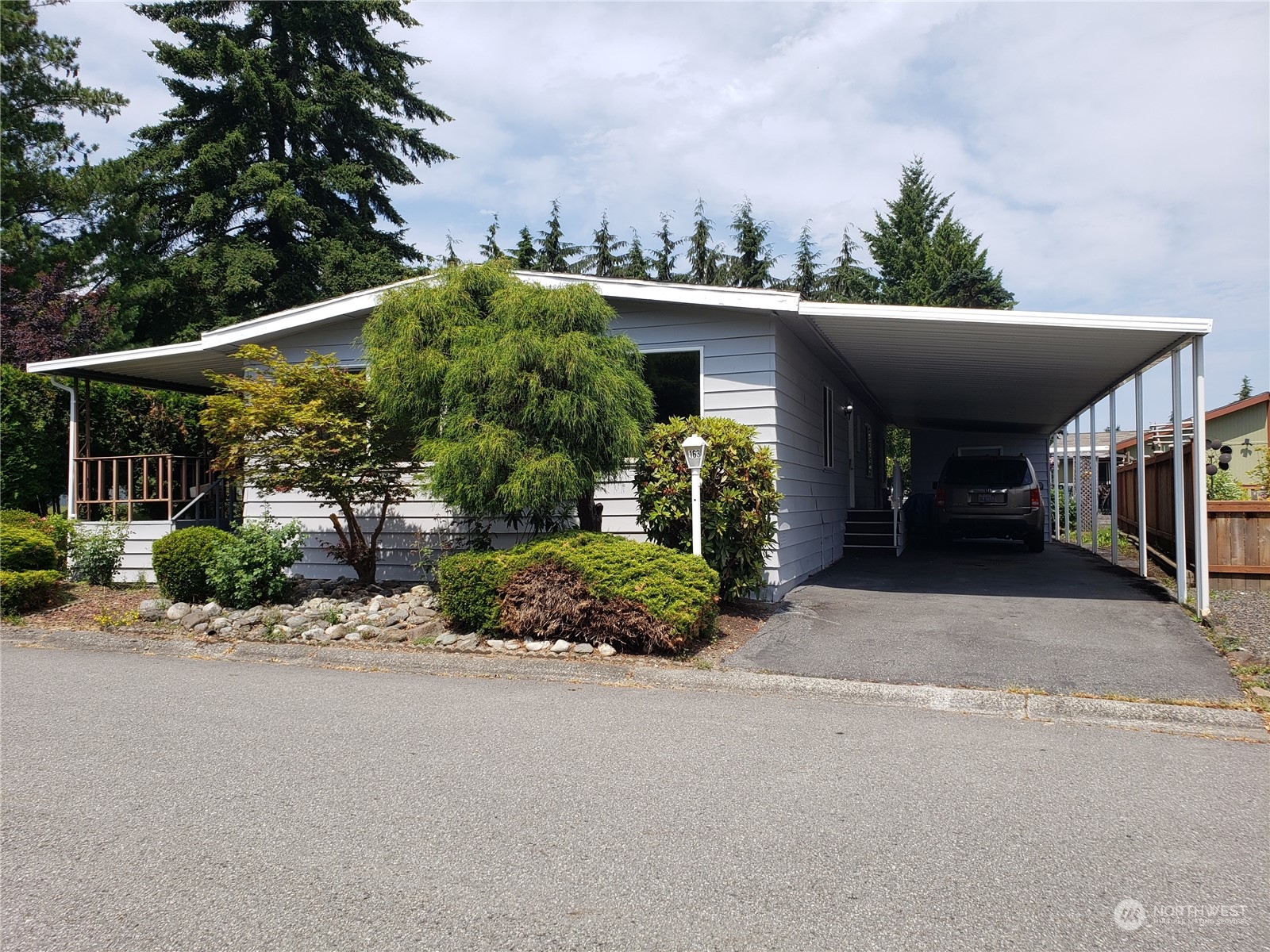 front view of a house with a yard and potted plants