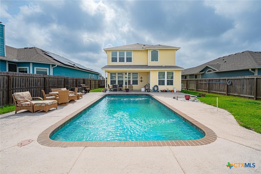 a view of a house with swimming pool and sitting area