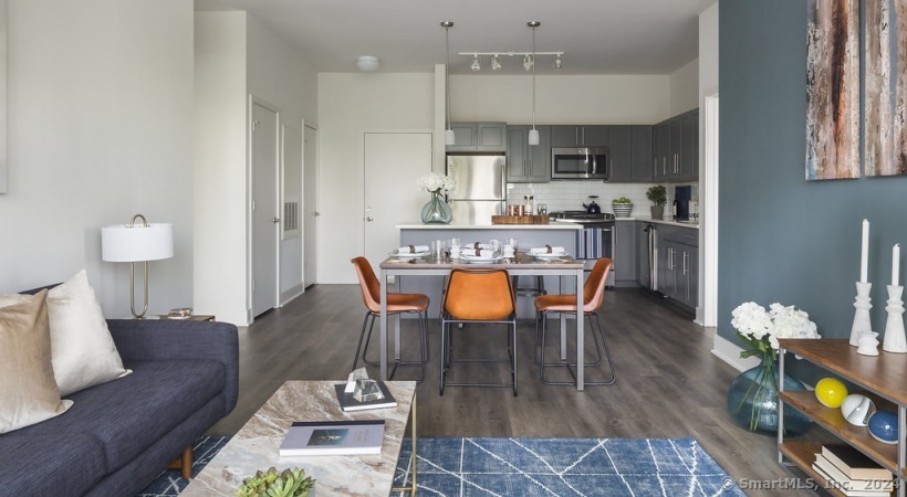 a living room with furniture a flat screen tv and kitchen view