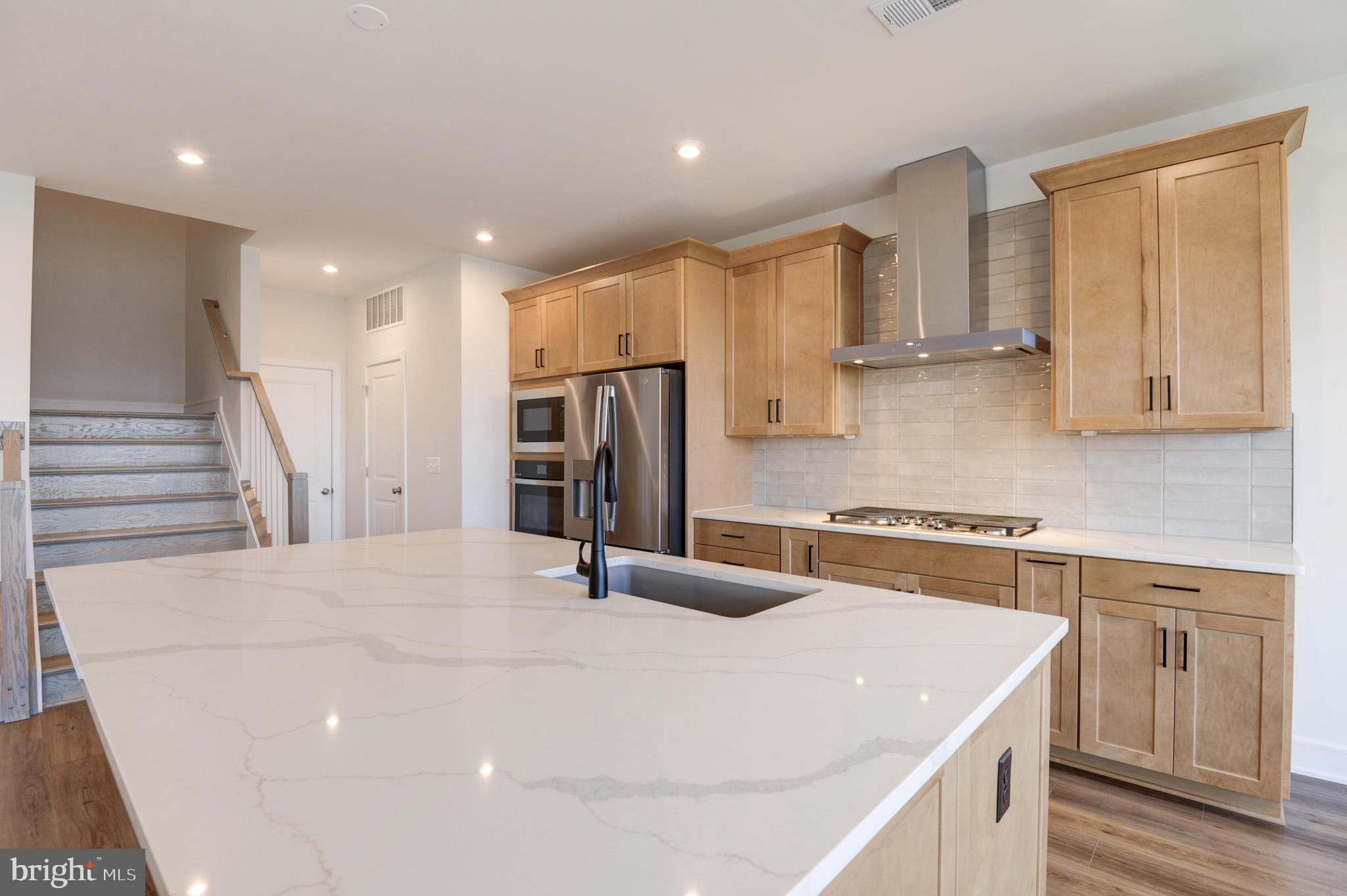 a kitchen with stainless steel appliances a refrigerator sink and cabinets