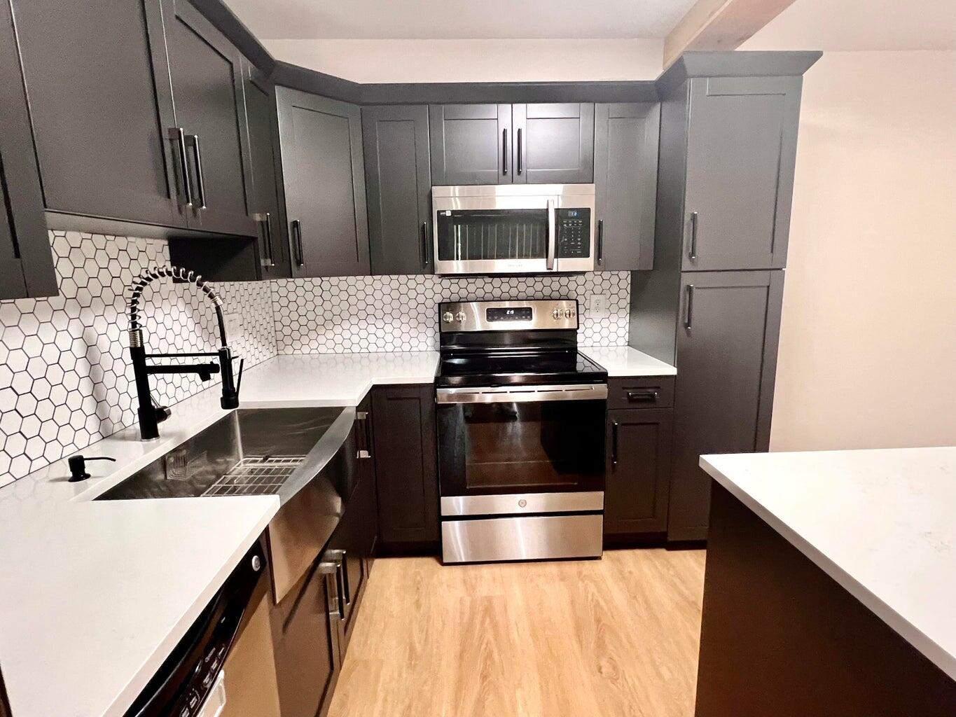 a kitchen with a sink and steel appliances