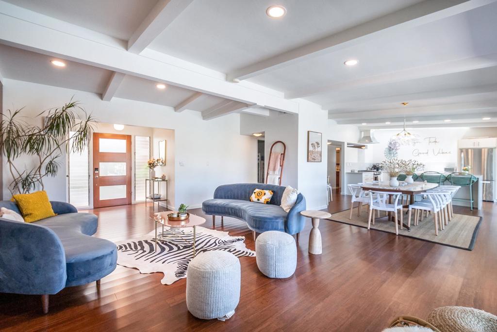 a living room with furniture kitchen view and a large window