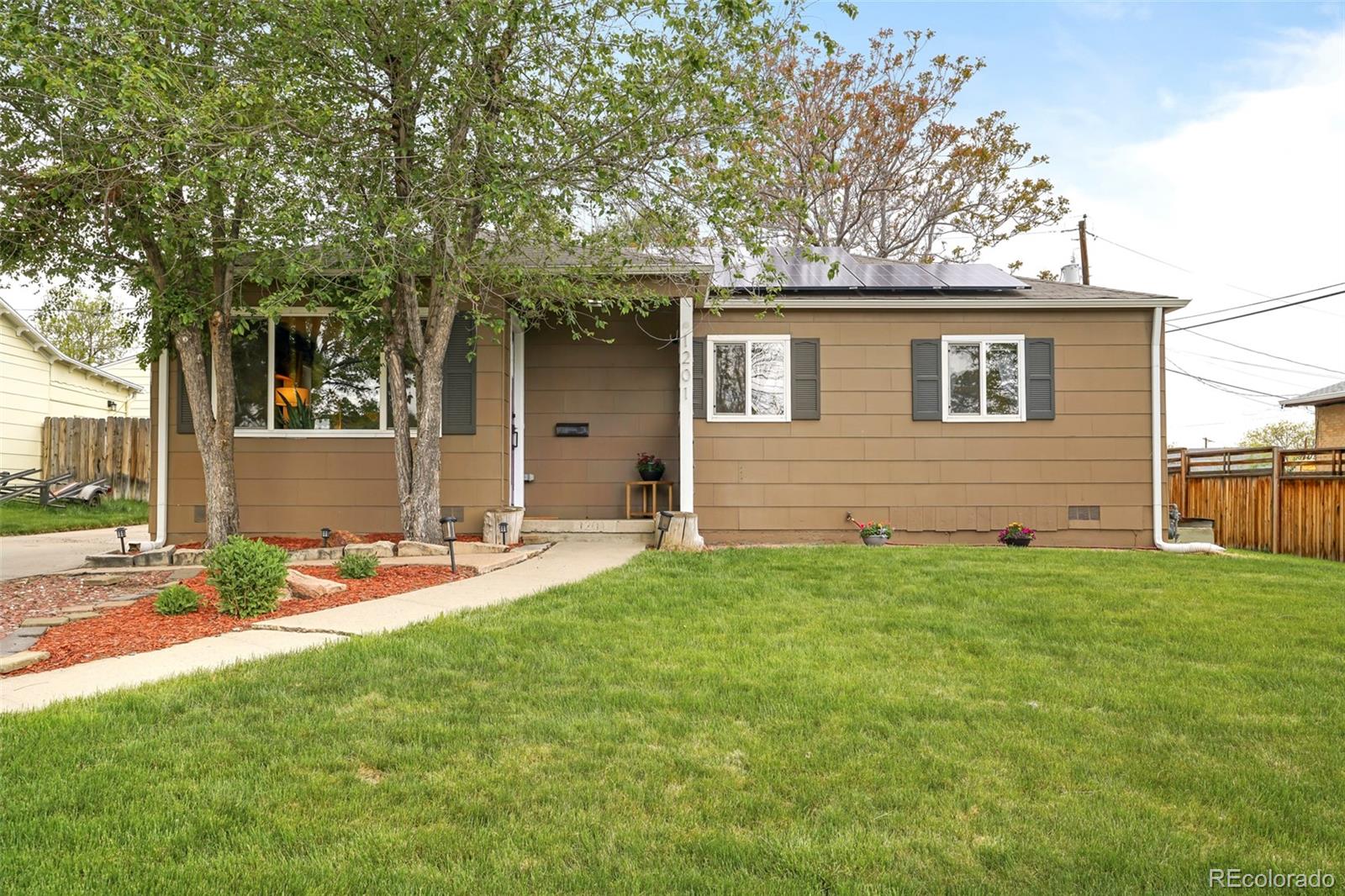 front view of a house with a yard and trees