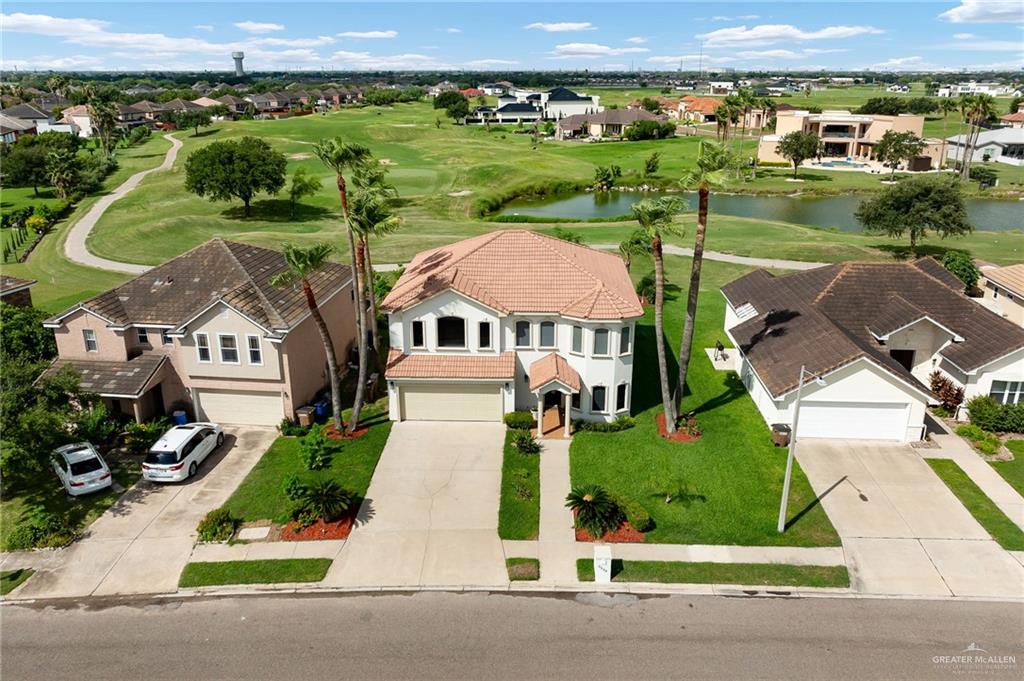 an aerial view of a house with a garden and lake view