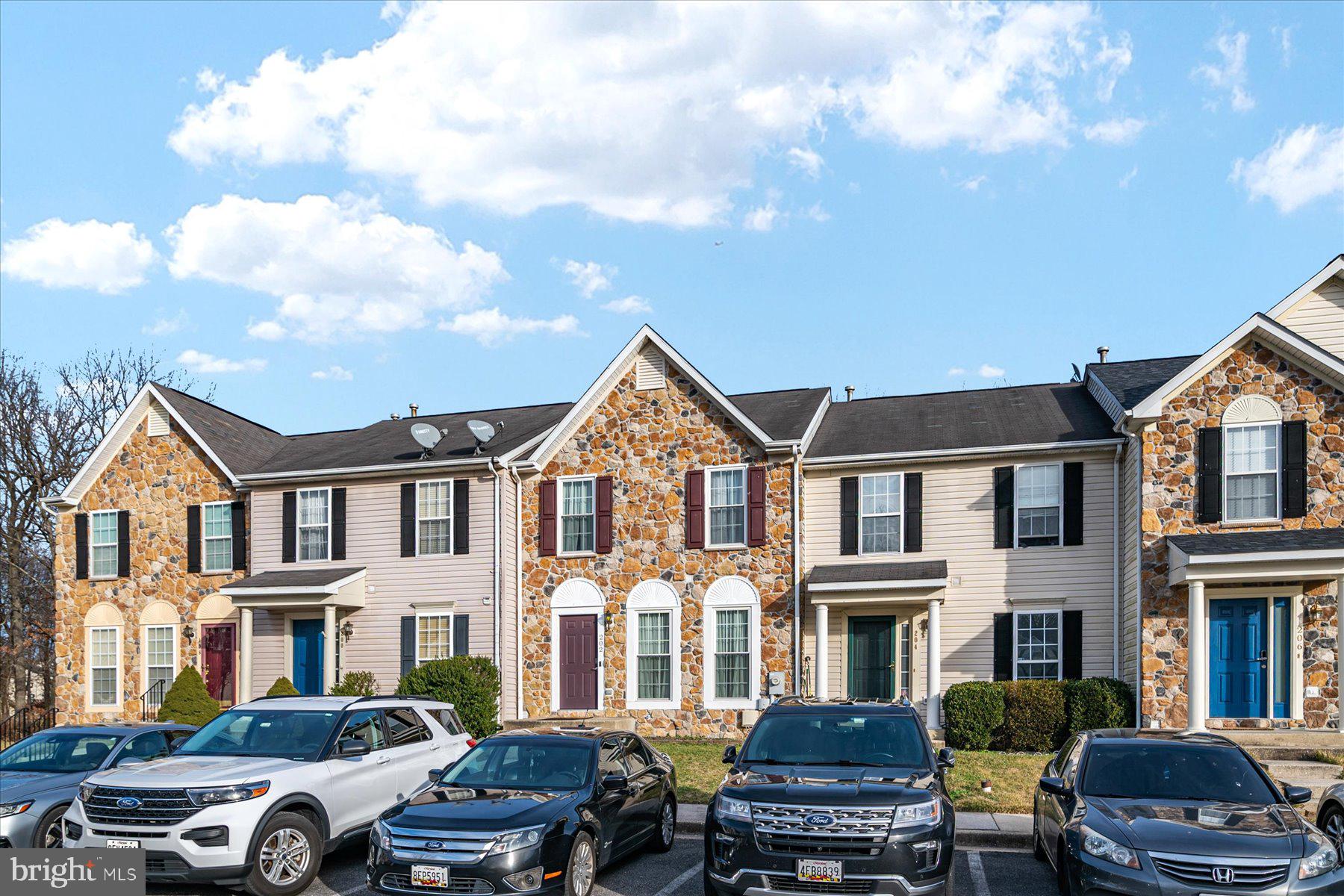 a front view of residential houses with cars parked