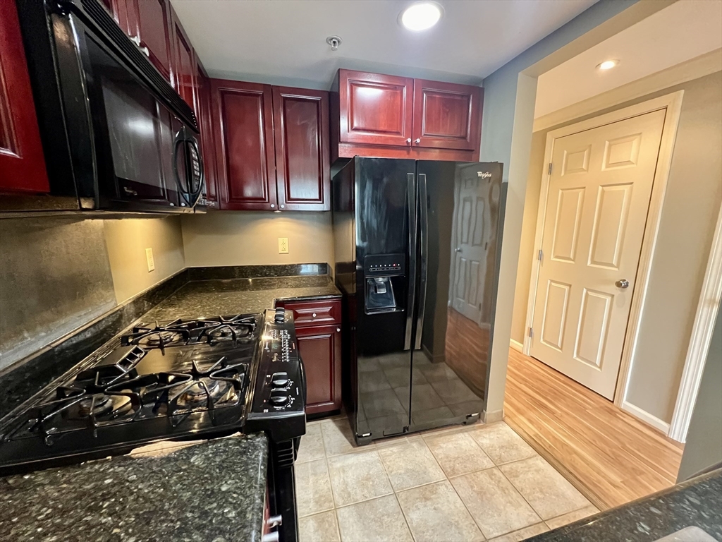 a kitchen with stainless steel appliances granite countertop a refrigerator and a stove