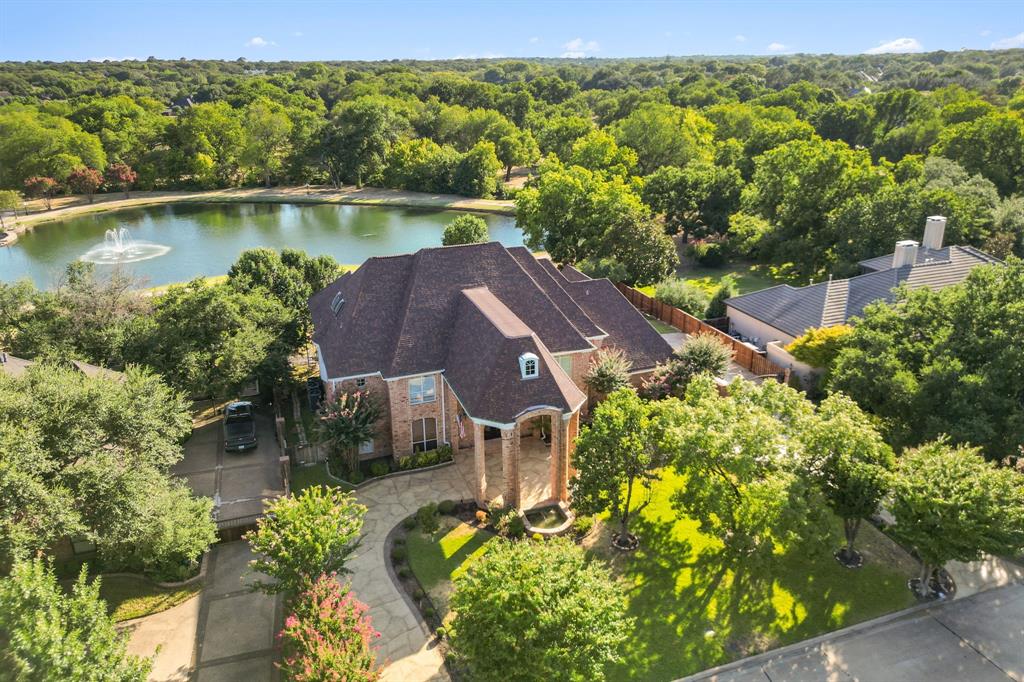 an aerial view of a house with a garden and lake view