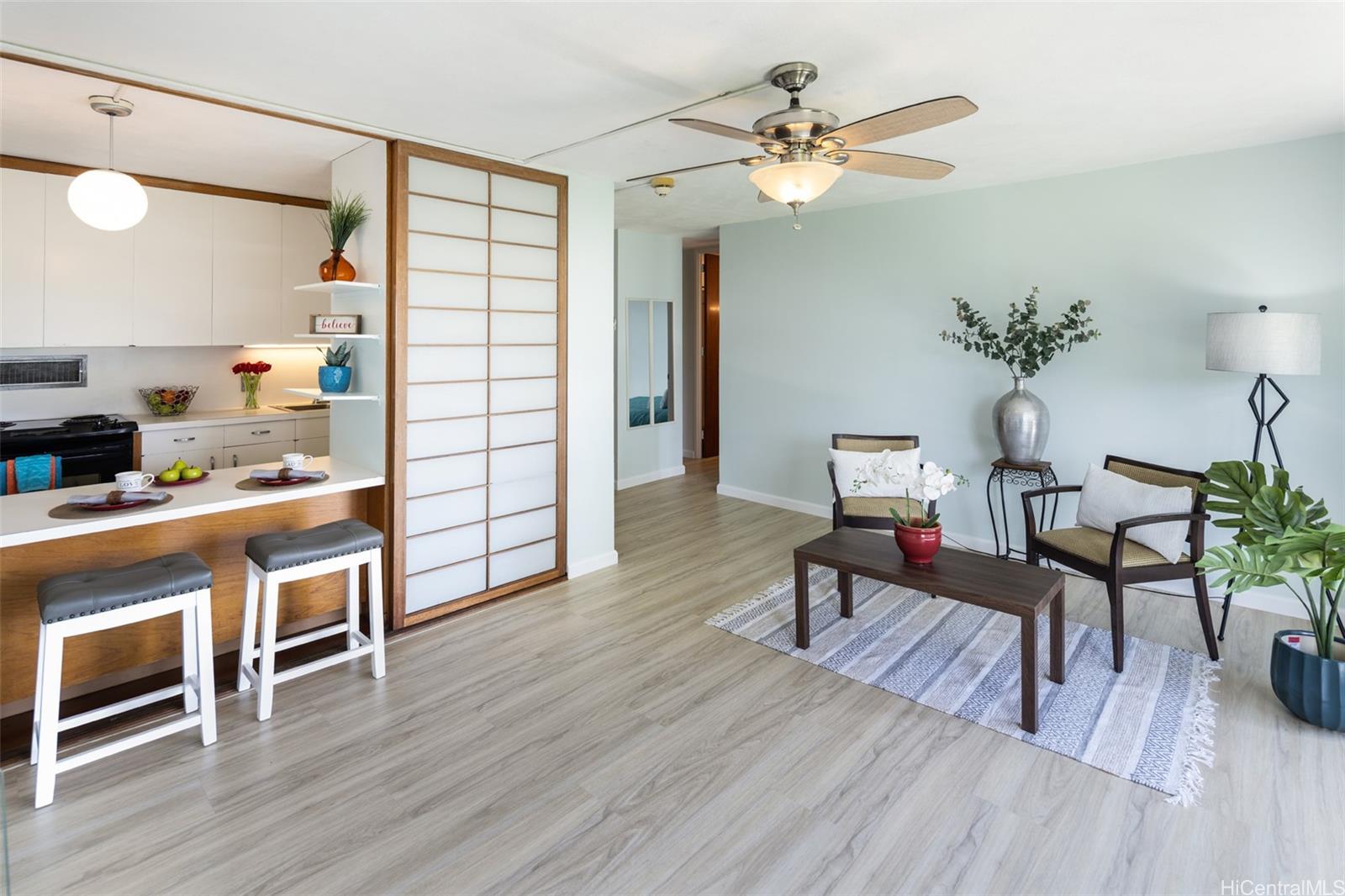 a living room with furniture a fireplace and wooden floor