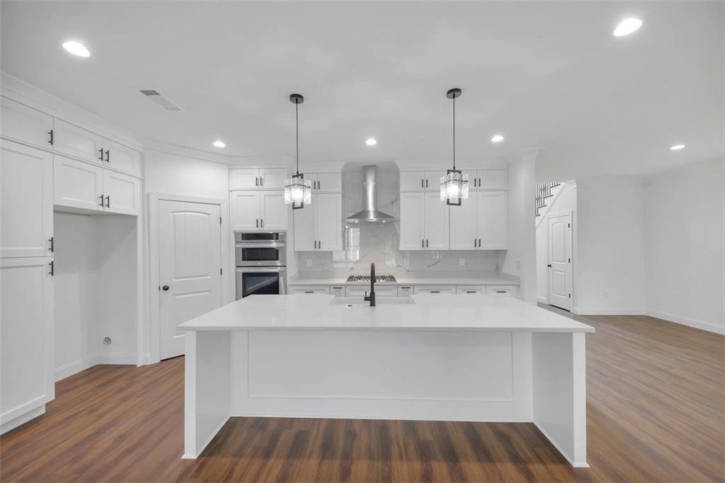 a large kitchen with a sink and a refrigerator