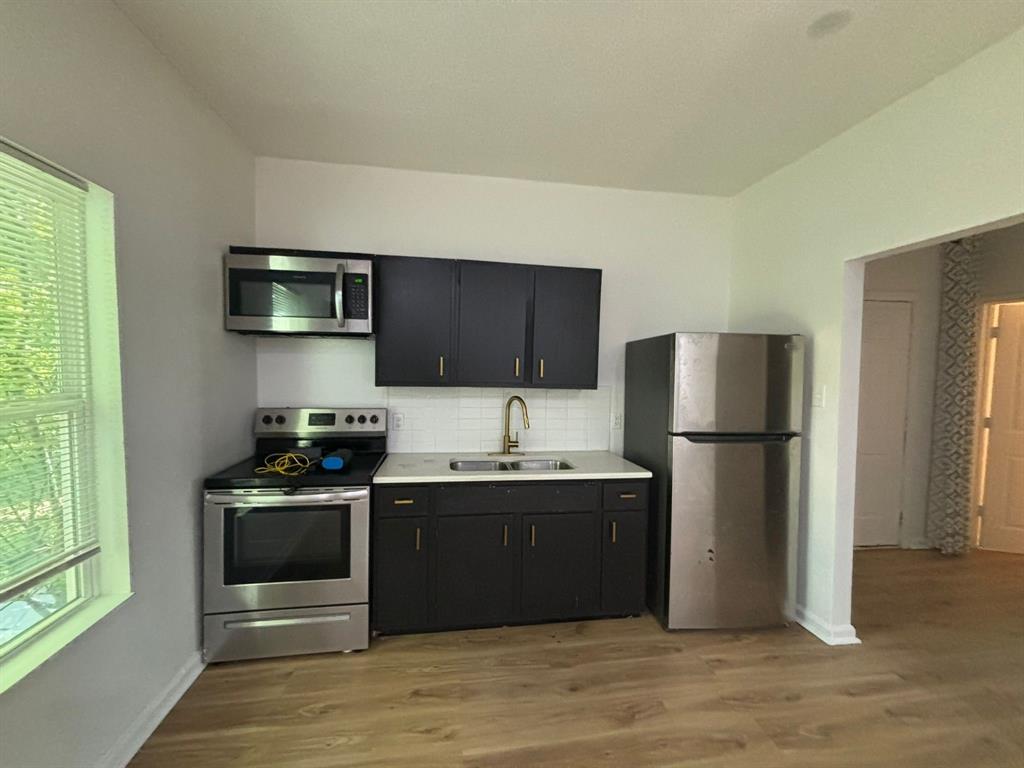 a kitchen with stainless steel appliances granite countertop a refrigerator stove and sink