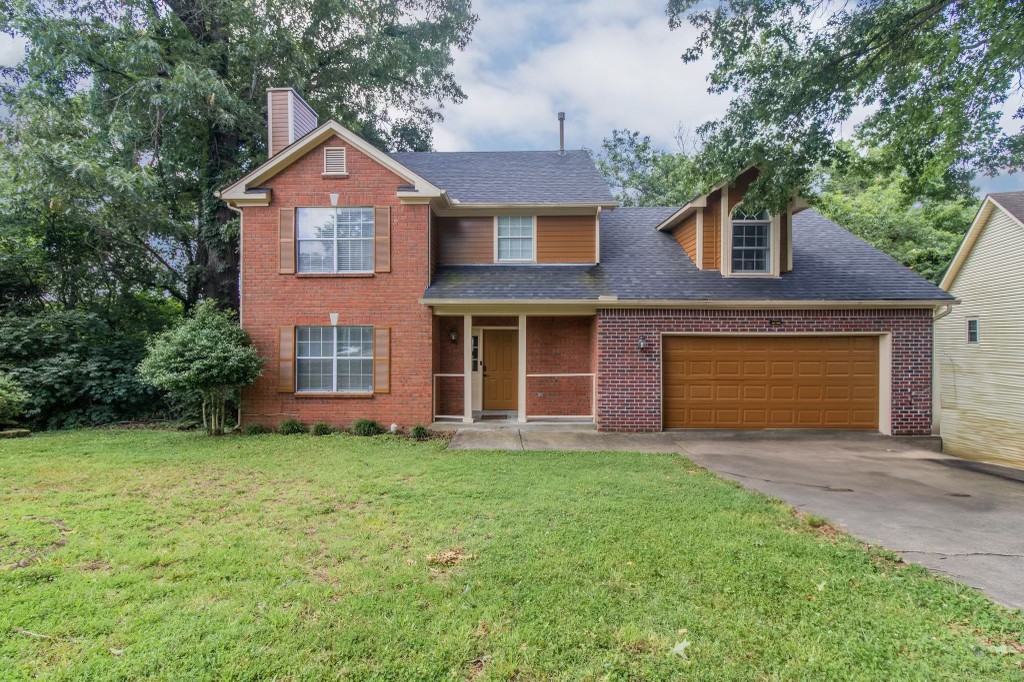 a front view of a house with a yard and garage