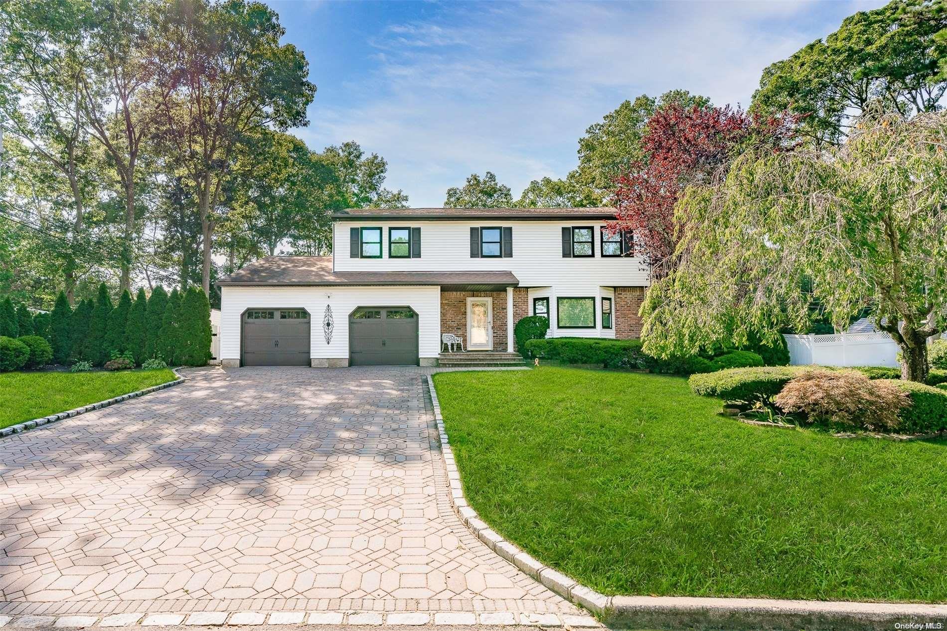 a front view of a house with a yard and trees