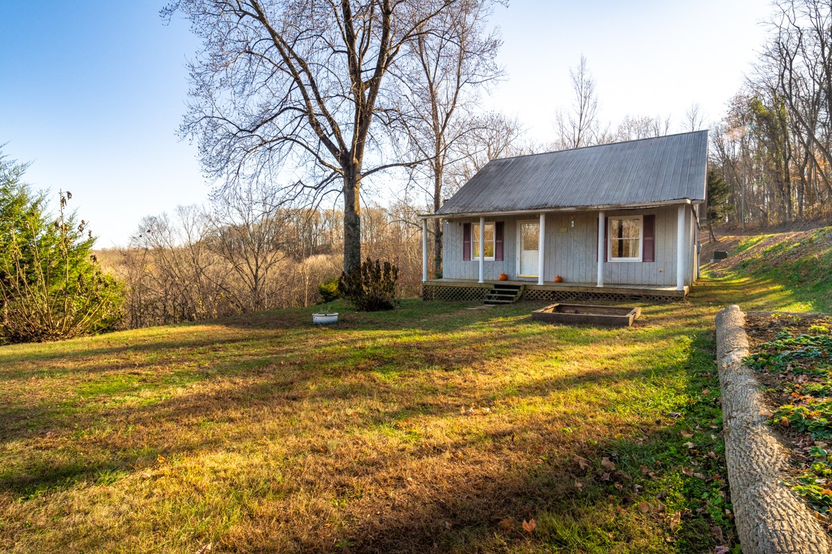 a front view of house with yard and trees in the background