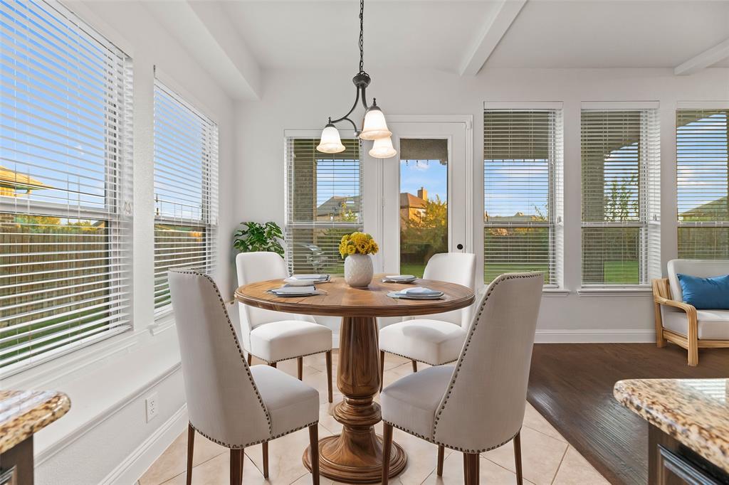 a dining room with furniture a large window and wooden floor