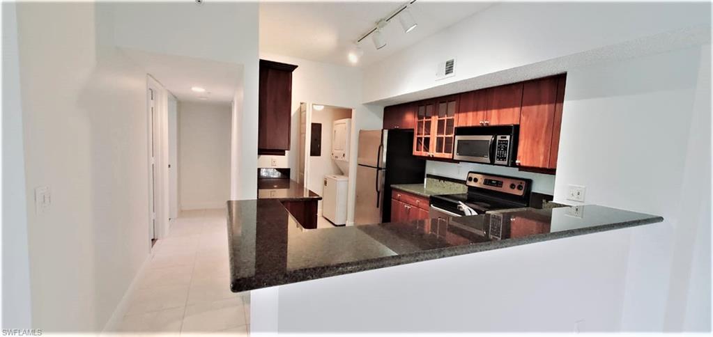 a living room with stainless steel appliances furniture a fireplace and a flat screen tv