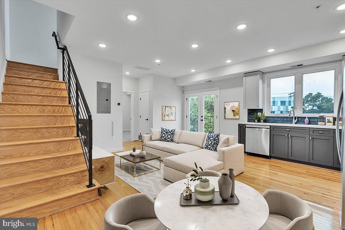 a living room with furniture kitchen and a wooden floor