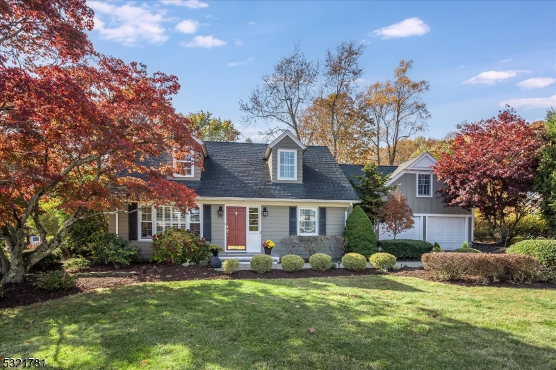 a front view of a house with a garden and tree