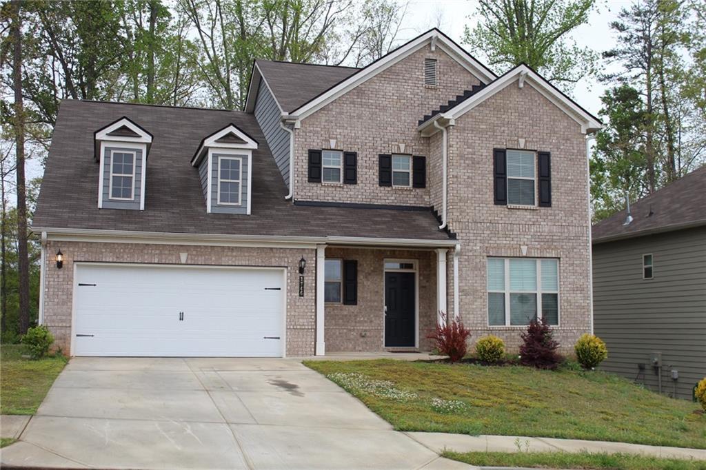 a front view of a house with a yard and garage