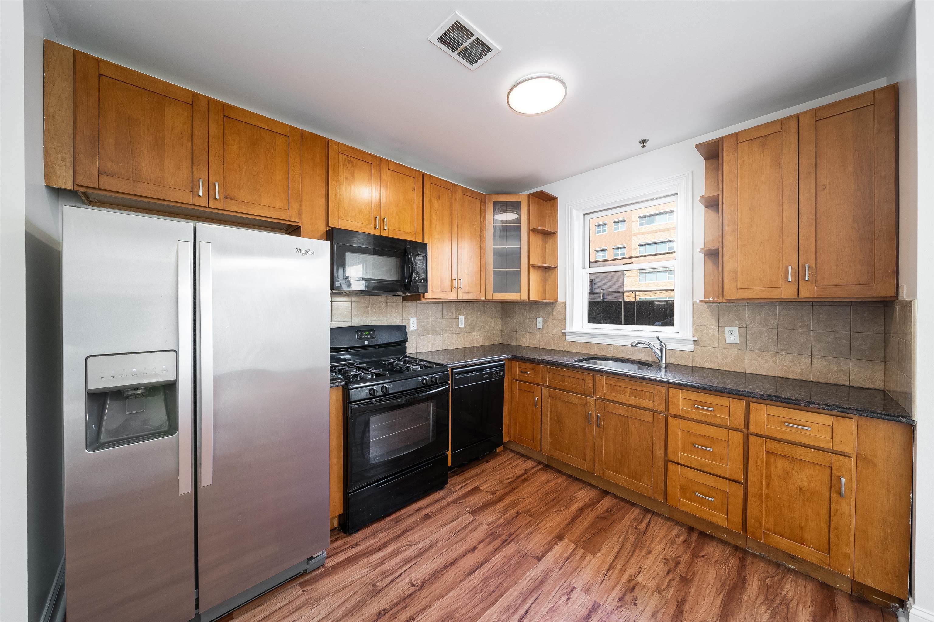 a kitchen with stainless steel appliances granite countertop a refrigerator stove top oven and sink